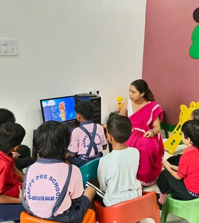 Children watching a lesson on the computer with their teacher